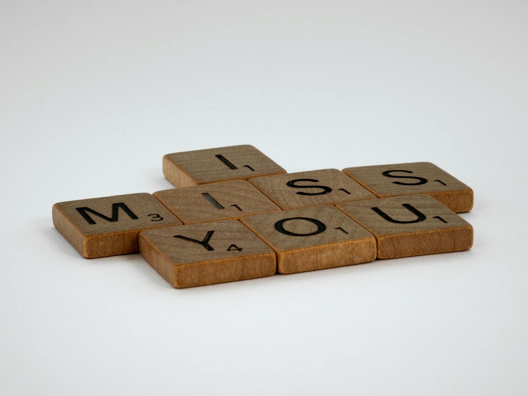 Kafelki Scrabble układające się w napis I miss you na białym tle